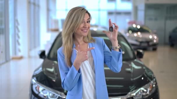 Zoom Happy Woman Showing Car Key Looking Camera Standing Dealership — Stockvideo