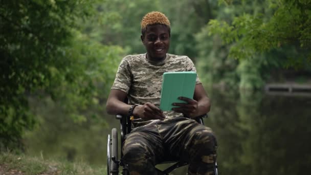 Afroamerikanisch Lächelnder Soldat Der Rollstuhl Seeufer Sitzt Und Beim Videochat — Stockvideo