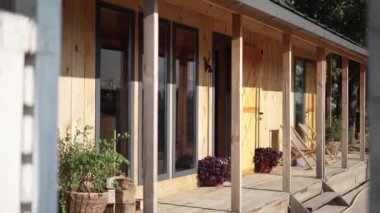 Güneşli bir yaz gününde, hiç insan olmadan, kırsal eko otelin rahat manzarası. Gün ışığında sakin bir yerde ahşap teras. Turizm ve sükunet kavramı