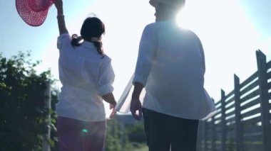 Arka plan mutlu çift gün batımında bahçede yürüyorlar etrafa bakıp gülümsüyorlar. Yazın eko turizmin tadını çıkaran heyecanlı yetişkin Kafkasyalı karı ve kocanın çekimleri.