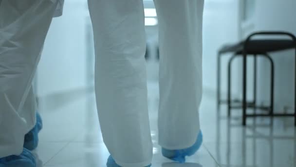 Live Camera Follows Legs Doctors White Uniform Shoe Covers Walking — Stockvideo