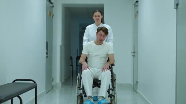 Wide Shot Portrait Positive Doctor Talking Patient Pushing Wheelchair Hospital — Video