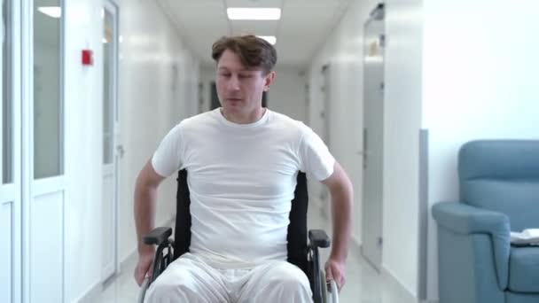 Man Rolling Wheelchair Hospital Corridor Looking Front View Portrait Caucasian — Stockvideo