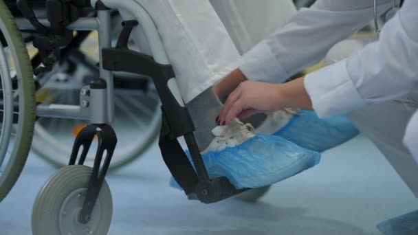 Close Nurse Putting Shoes Feet Ill Patient Wheelchair Hospital Unrecognizable — Stockvideo