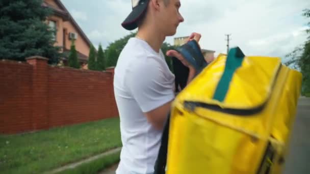 Live Camera Follows Yellow Delivery Bag Young Man Putting Backpack — Vídeo de Stock
