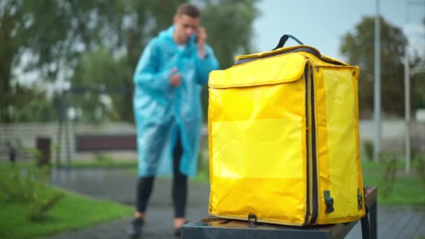 Close Yellow Backpack Blurred Delivery Boy Talking Phone Background Unrecognizable — Vídeo de Stock