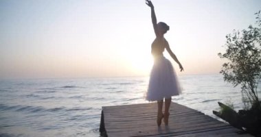 Wide shot confident graceful young woman in tutu and pointies performing in slow motion on the right in sunrays. Caucasian beautiful ballerina dancing in sunshine at sunset. Cinema 4k ProRes HQ