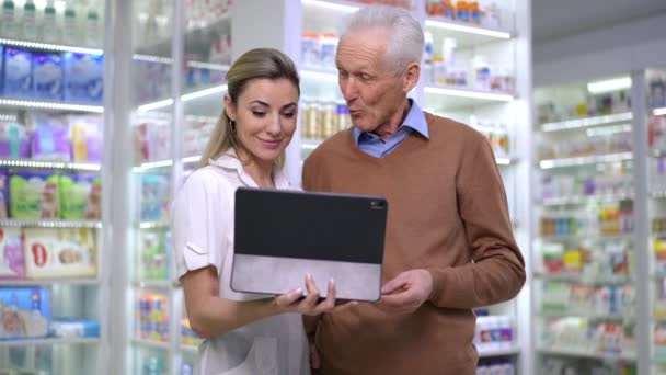 Positive Friendly Young Woman Talking Senior Man Standing Pharmacy Digital — Stockvideo