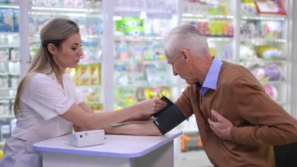 Фармацевт Боковым Видом Измеряет Артериальное Давление Нездорового Старшего Клиента Аптеке — стоковое видео