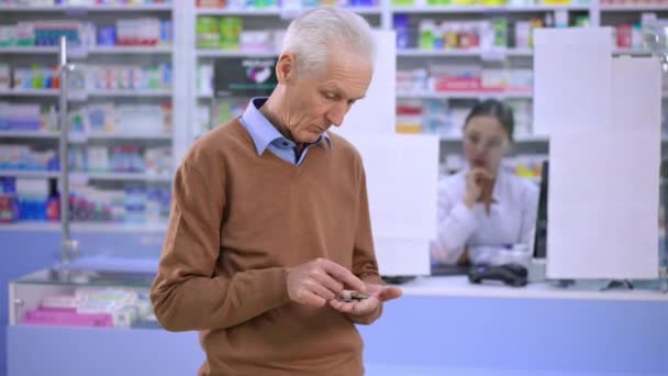 Sad Poor Senior Caucasian Man Counting Coins Standing Pharmacy Looking — Stockvideo