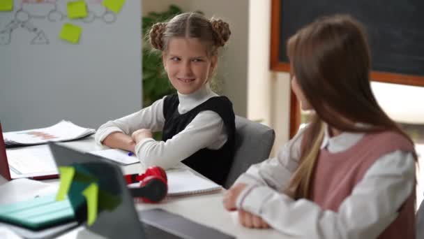Charming Positive Teenage Schoolgirl Gesturing High Five Classmate Sitting Desk — Vídeos de Stock