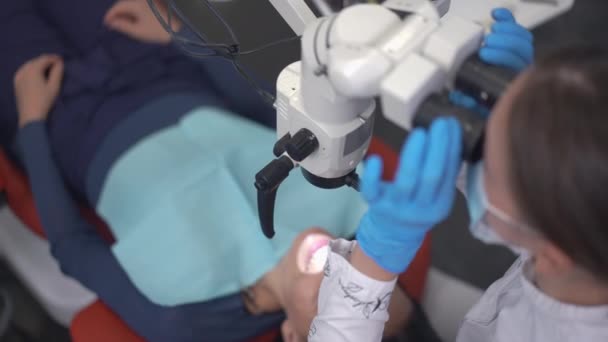 Top View Dental Microscope Blurred Patient Lying Background Concentrated Doctor — Video