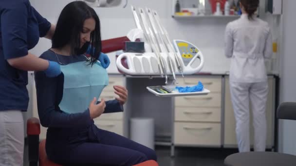 Side View Woman Sitting Dental Chair Assistant Putting Dental Napkin — Stockvideo