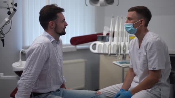 Side View Positive Male Patient Dentist Talking Slow Motion Sitting — Stok video