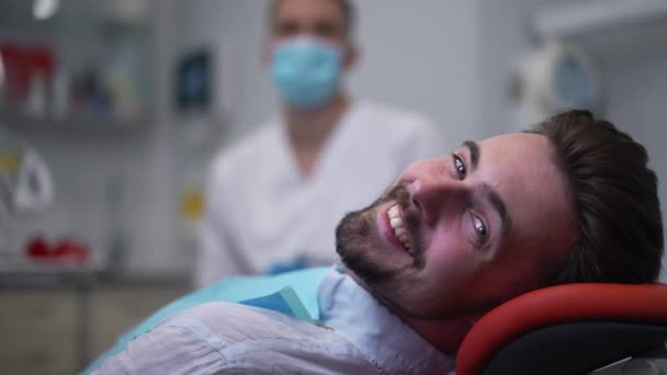 Satisfied Happy Man Smiling Looking Camera Sitting Dental Chair Blurred — Stock video