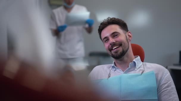 Happy Man Dental Chair Laughing Slow Motion Looking Away Blurred — Stockvideo