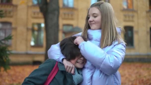 Teenage Girl Rubbing Hair Cute Little Boy Bullying Standing Outdoors — Stockvideo