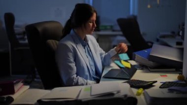 Overburdened Caucasian manager closing laptop leaving dark office indoors. Young tired exhausted woman sighing walking away. Business stress and overworking concept