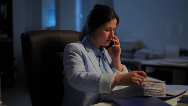 Умная Молодая Занятая Женщина Разговаривающая Телефону Анализируя Документы Сидящие Офисе — стоковое видео