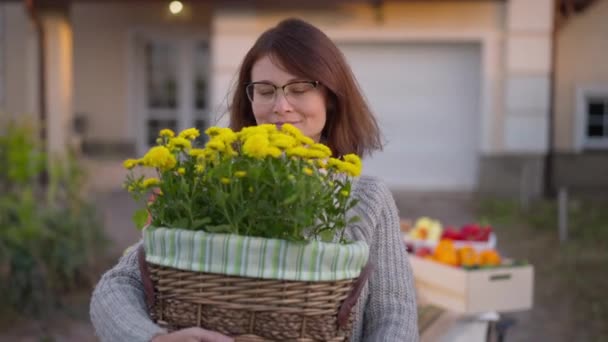 Beautiful Smiling Adult Woman Smelling Yellow Flowers Basket Standing Outdoors — Video