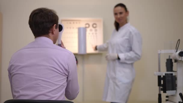 Back View Unrecognizable Man Undergoing Eyesight Test Gesturing Sitting Left — Stock video