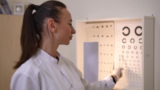 Portrait Confident Smart Woman Pointing Blurred Eyesight Test Chart Looking — Vídeo de stock