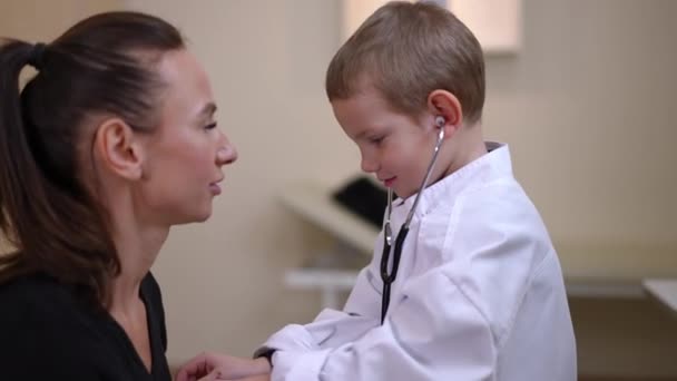 Side View Positive Curios Little Boy Using Stethoscope Talking Young — Vídeo de Stock