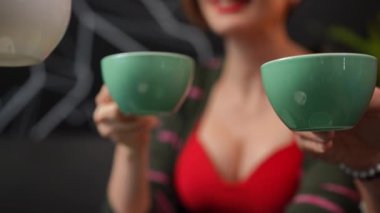 Close-up unrecognizable friends clinking coffee cups meeting in cafe indoors. Happy relaxed carefree Caucasian men and women drinking tasty hot drink in coffee shop on weekend