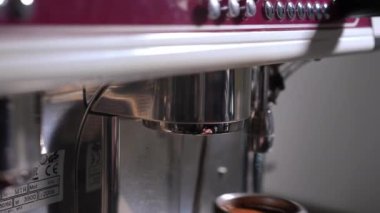 Close-up attaching portafilter to espresso machine indoors in cafe. Unrecognizable male Caucasian barista preparing professional equipment making hot drink in coffee shop