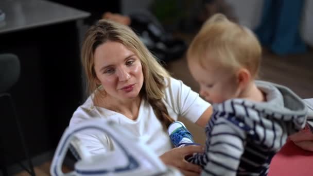 Beautiful Caucasian Happy Mother Talking Infant Daughter Sitting Ironing Board — Vídeos de Stock