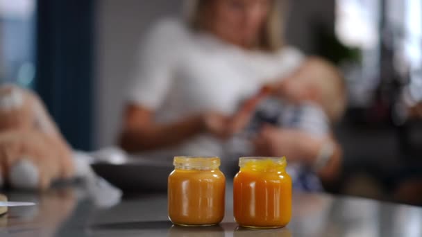 Close Glass Bottles Baby Food Blurred Unrecognizable Woman Feeding Child — Stok video