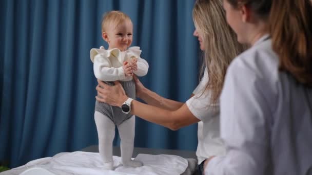 Wide Shot Portrait Adorable Baby Girl Smiling Standing Table Pediatric — Vídeo de stock