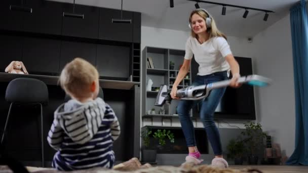Wide Shot Joyful Woman Headphones Dancing Vacuum Cleaner Singing Admiring — стоковое видео