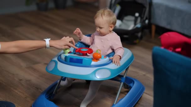 Concentrated Adorable Little Girl Sitting Baby Walker Female Hand Pressing — Wideo stockowe