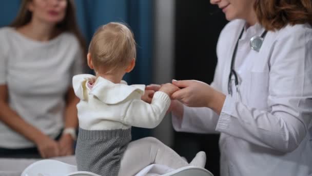 Happy Baby Girl Sitting Scales Holding Hands Pediatrician Looking Back — Stok Video