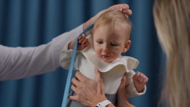Medium Shot Curios Toddler Examining Measuring Tape Doctor Mother Taking — Vídeos de Stock