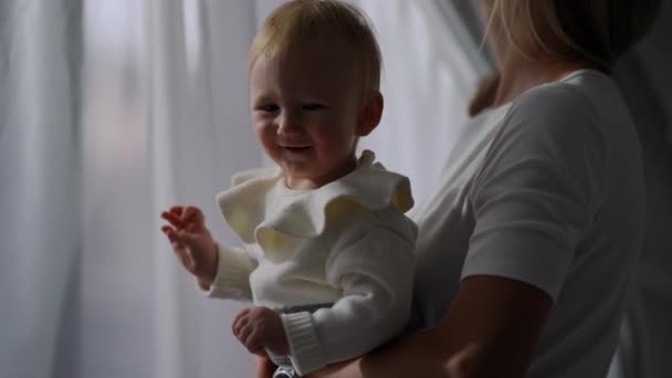 Medium Shot Portrait Smiling Baby Girl Hands Unrecognizable Woman Indoors — 图库视频影像