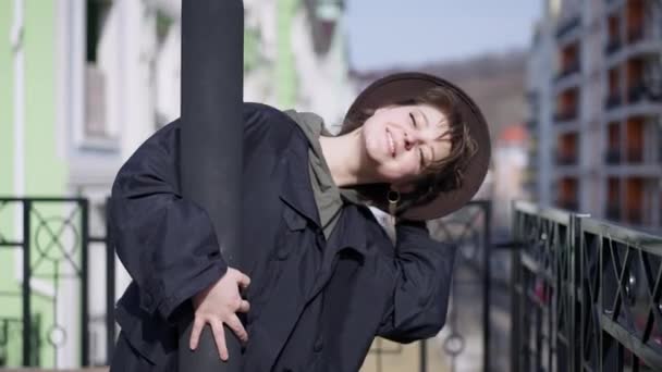 Medium Shot Joyful Smiling Young Woman Hugging Lamp Pole Standing — стоковое видео