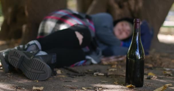 Butelka Wina Bliska Zamazaną Bezdomną Kobietą Śpiącą Pod Drzewem Biały — Wideo stockowe