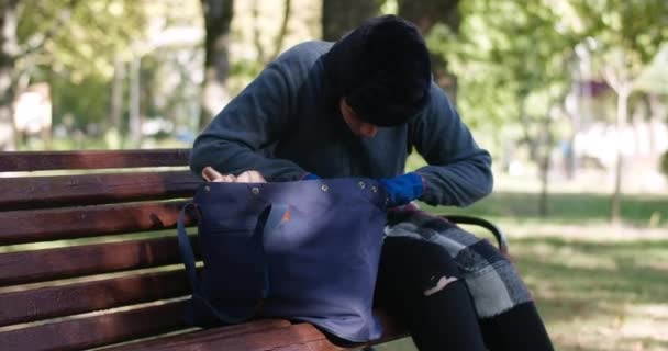 Zaostřená Bezdomovkyně Pomalu Přehrabuje Tašce Sedí Lavičce Slunečném Parku Portrét — Stock video