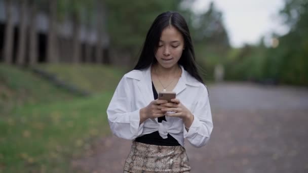 Portret Van Geabsorbeerde Aziatische Elegante Vrouw Berichten Online Smartphone Lopen — Stockvideo