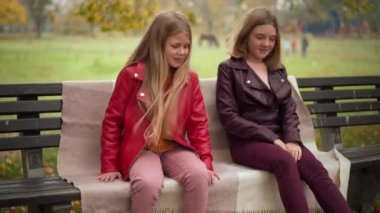Sonbahar parkında battaniyeli bankta oturan iki mutlu genç kız. Kaygısız Kafkasyalı arkadaşlar dedikoduları paylaşıyorlar hafta sonları açık havada sohbet ediyorlar.