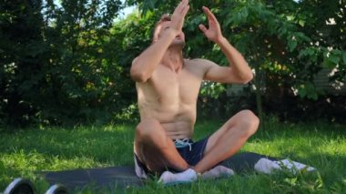 Kendine güvenen bir adam ellerini dizlerinin üstüne koyar gözlerini kapatır dışarıda nilüfer pozu verir. Kafkas yogi sporcu eğitiminin portresi güneşli yeşil arka bahçede meditasyon yapıyor. Yaşam dengesi kavramı