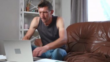Bilgisayar oyunu meditasyonunda kaybeden bilgisayarla oyun oynayan özümseyici. Oturma odasında kanepede dinlenen yetişkin beyaz erkek oyuncunun portresi. Hobi ve yaşam tarzı