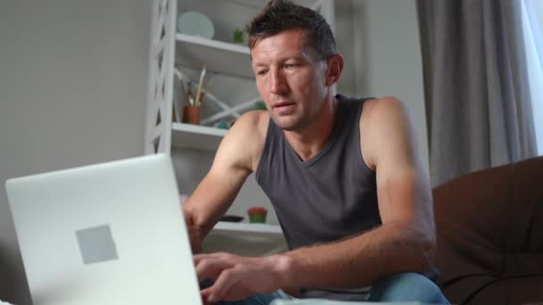 フリーランサーの肖像は 自宅のオフィスに座ってノートパソコン上でオンラインで頭痛のメッセージを持っている 悲しいの中出しストレスを受けた白人男性手に頭を持っています痛みを伴う顔の表情 — ストック動画