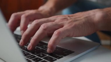 Erkek parmaklar yavaş çekimde klavye tuşlarına basıyor. Ofiste çevrimiçi çalışan tanımlanamayan beyaz bir adam. Modern teknolojiler ve serbest konsept