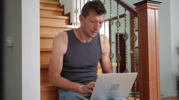 Homem Murmurando Digitando Teclado Laptop Sentado Nas Escadas Sala Estar — Vídeo de Stock