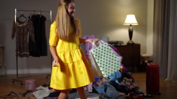 Zufriedenes Teenie Mädchen Betritt Wohnzimmer Mit Haufen Von Kleidern Die — Stockvideo