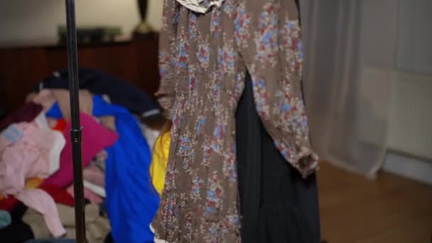 Askıda Asılı Duran Elbiseler Kameraya Bakan Genç Bir Kız Neşeli — Stok video