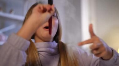 Makyaj fırçasına makyaj pudrasıyla dokunan neşeli genç kız. Gülümseyen Kafkas genci evde makyaj yaparken eğleniyor. Güzellik ve ergenlik